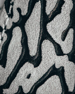 a close up of a black and white pattern on a wall Hand tufted rugs Kanha Universal Export