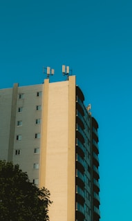 A multi-story building with telecom antennas and cables neatly arranged on the rooftop