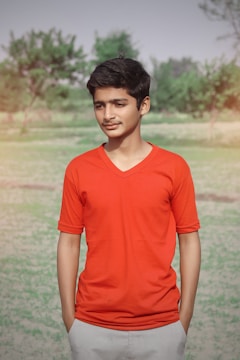 Young activists planting trees in an urban park wearing bright orange shirts.