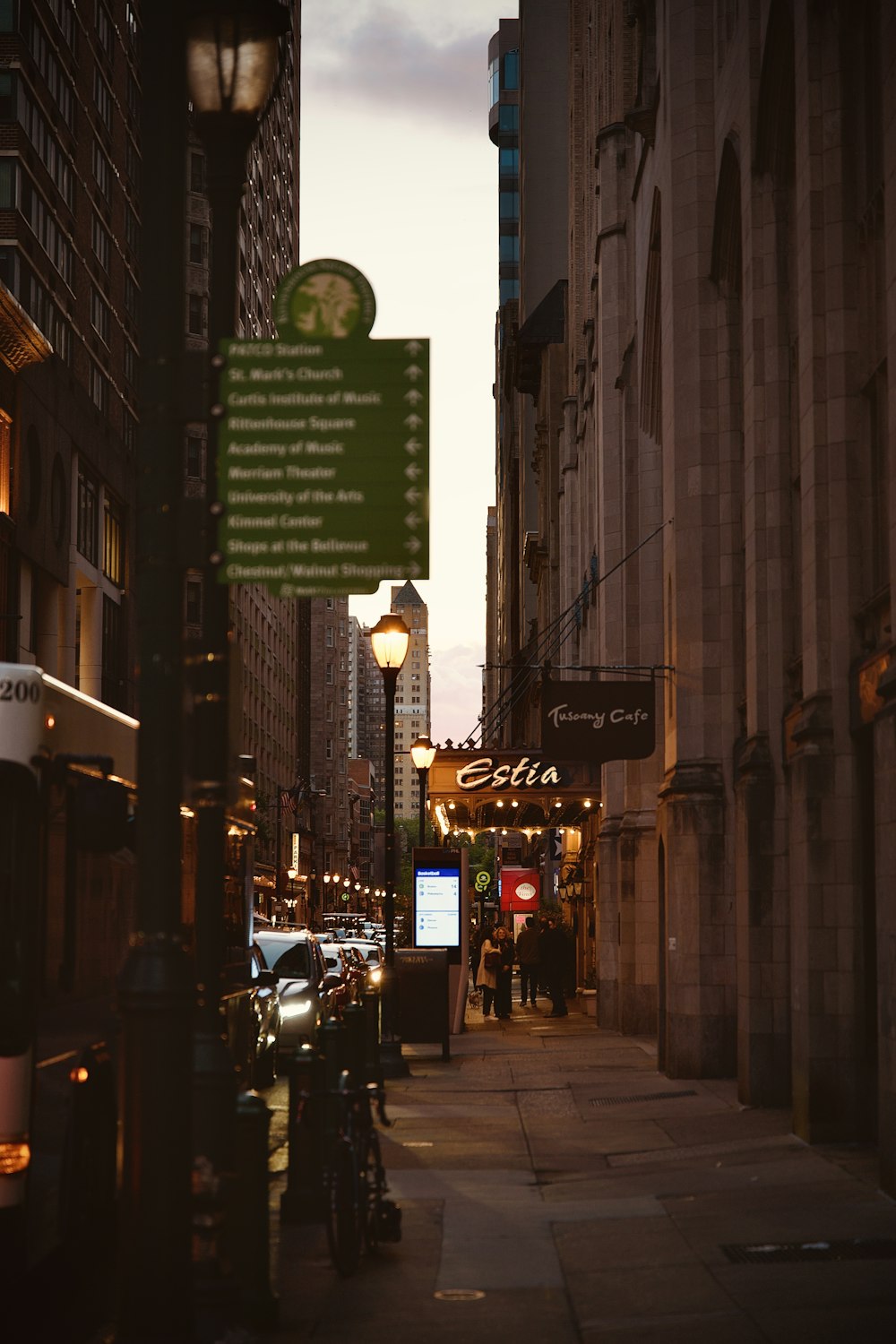 a city street at night with cars parked on the side of the street