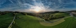 A panoramic view of lush green hills at sunrise.