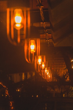 A row of industrial retro pendant lights hanging in a rustic setting.