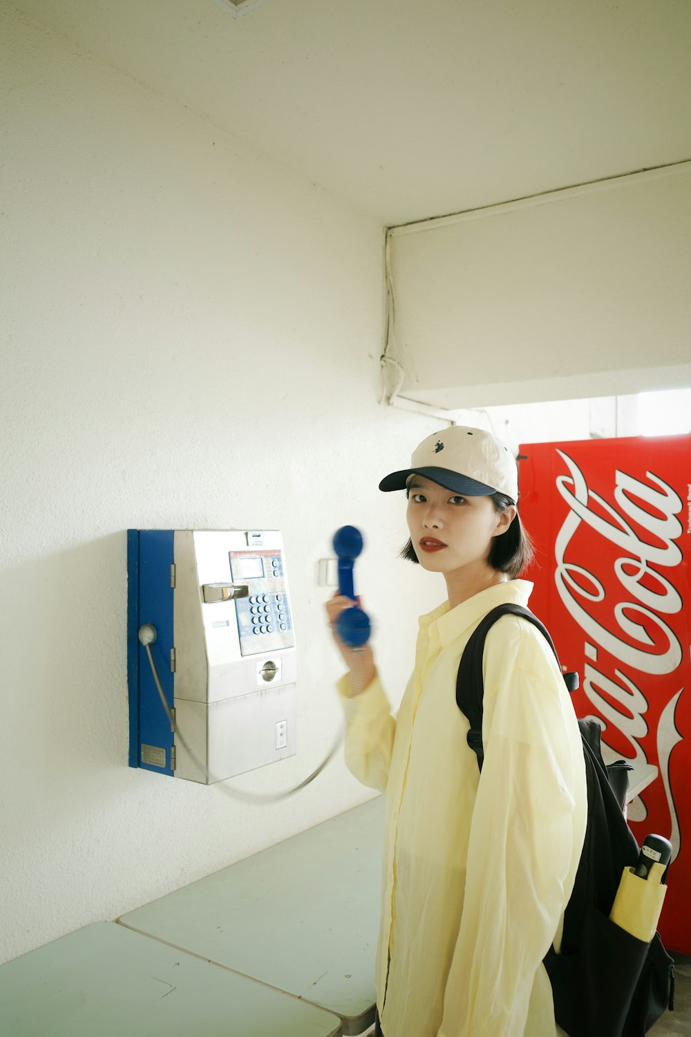 a woman in a baseball cap holding a cell phone