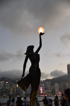 Close-up of a hand holding a glowing Omen token against a futuristic cityscape.