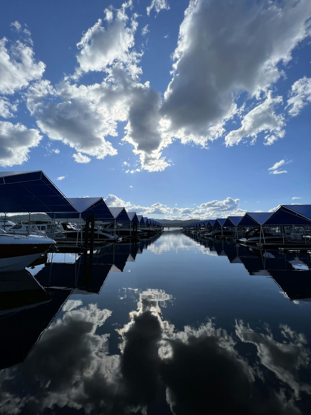 Un cuerpo de agua rodeado de barcos bajo un cielo azul nublado