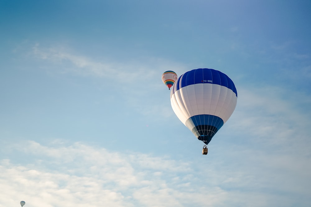 a blue and white hot air balloon flying in the sky