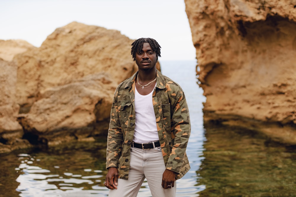 a man standing in front of a body of water