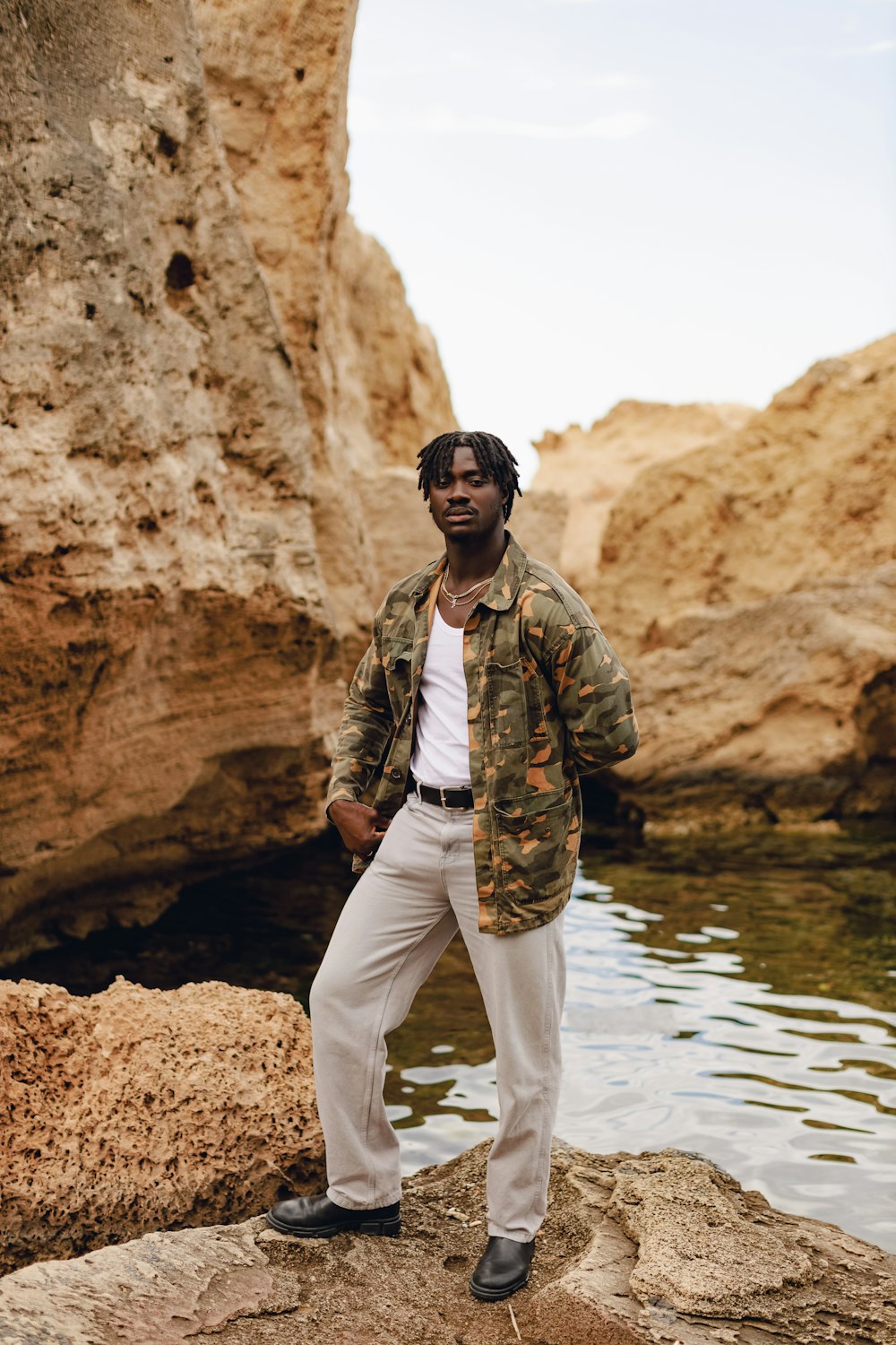 a man standing on a rock near a body of water