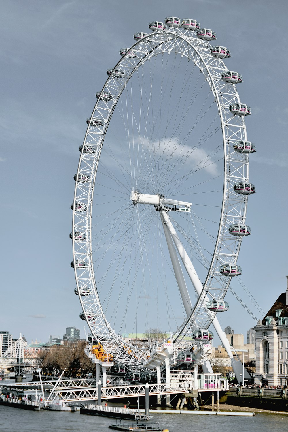 a large white ferris wheel sitting next to a body of water