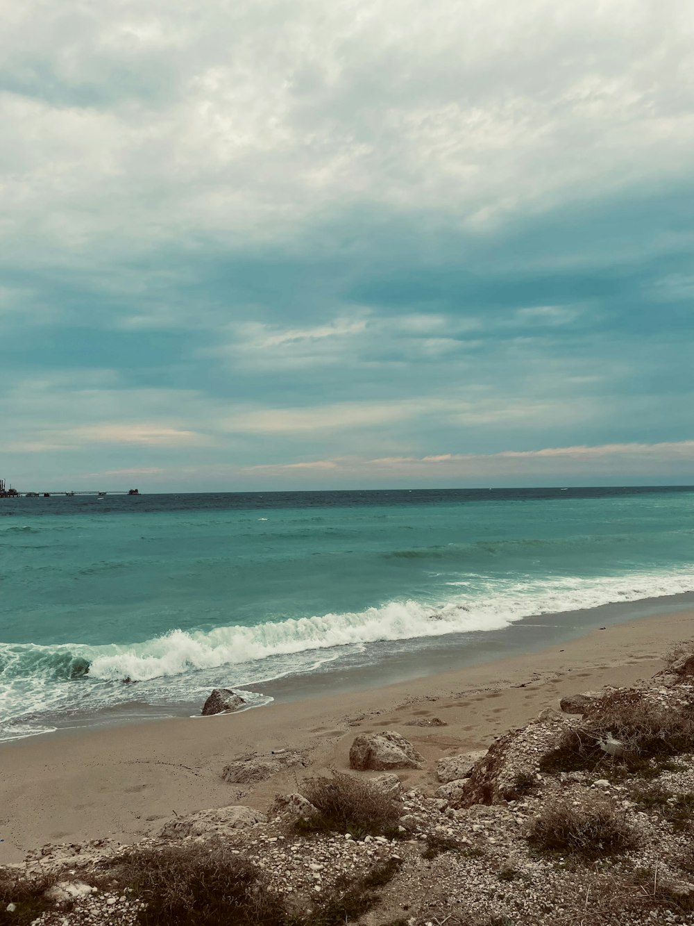 a person walking on the beach with a surfboard