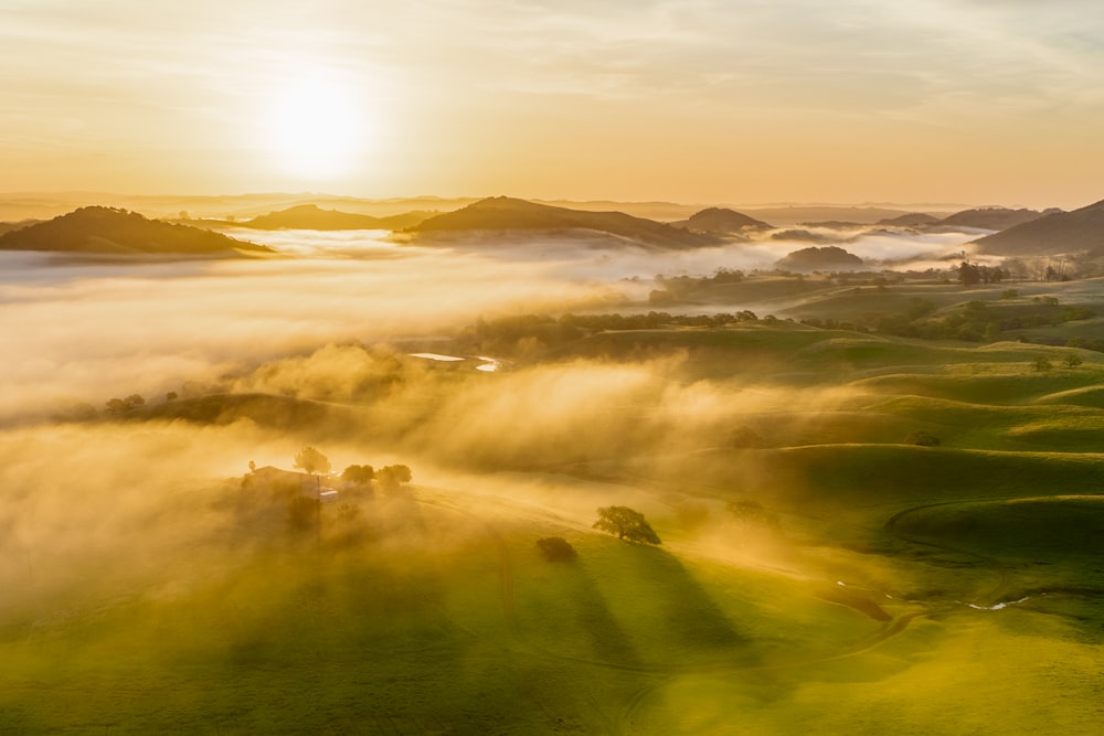 the sun is shining through the clouds in the valley