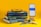 A stack of three mathematics textbooks is placed on a yellow surface, with a pair of black glasses resting on top. Nearby, a smartphone on a stand displays a calculator app showing the number pi. Various stationery items, including a pencil, eraser, and geometric tools, are also arranged nearby.