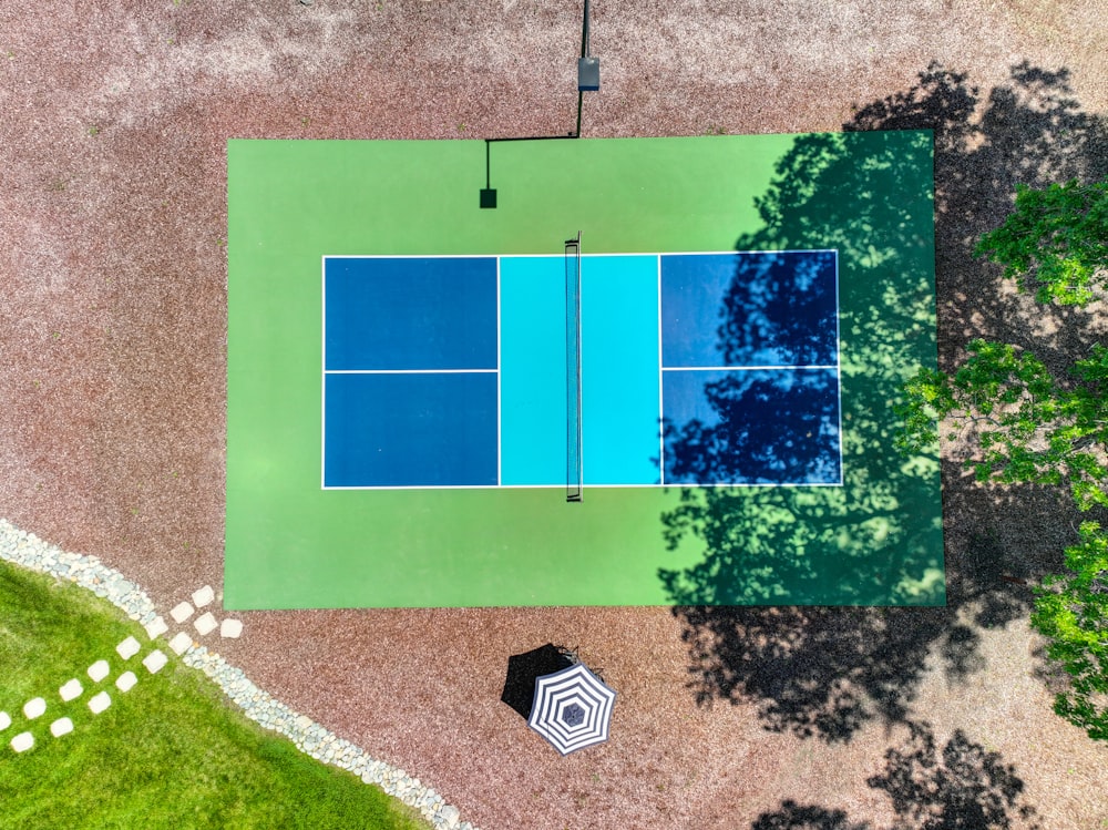 an aerial view of a tennis court with an umbrella