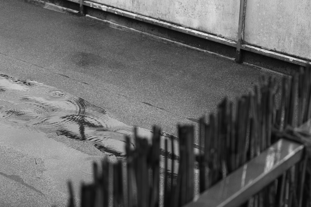 a black and white photo of a fence and street