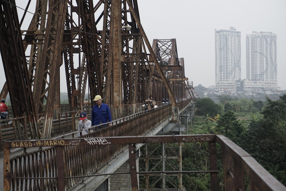 a group of people walking across a bridge