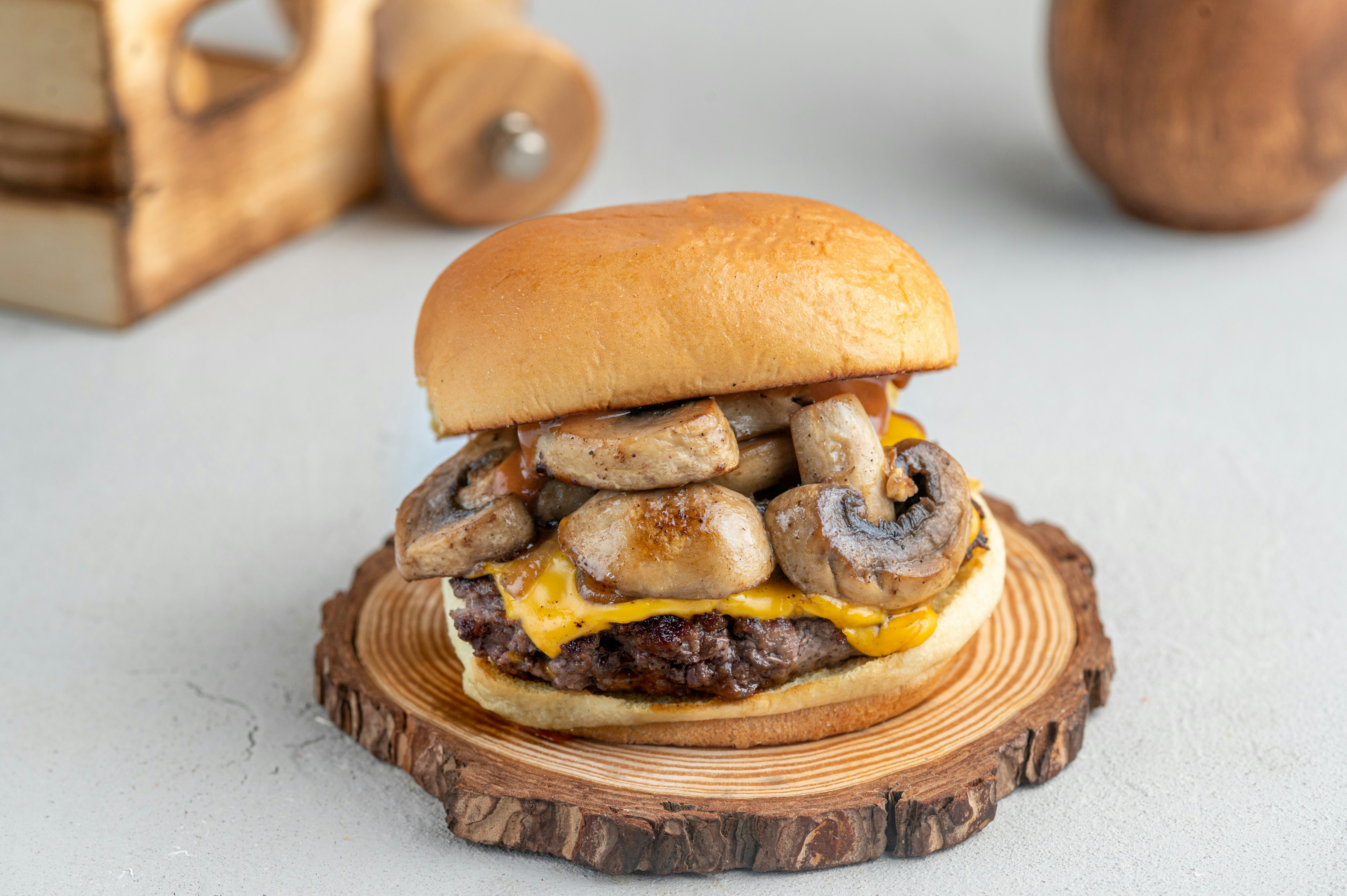 Sándwich caliente con queso derretido y vegetales, tabla de madera oscura, luz lateral cálida