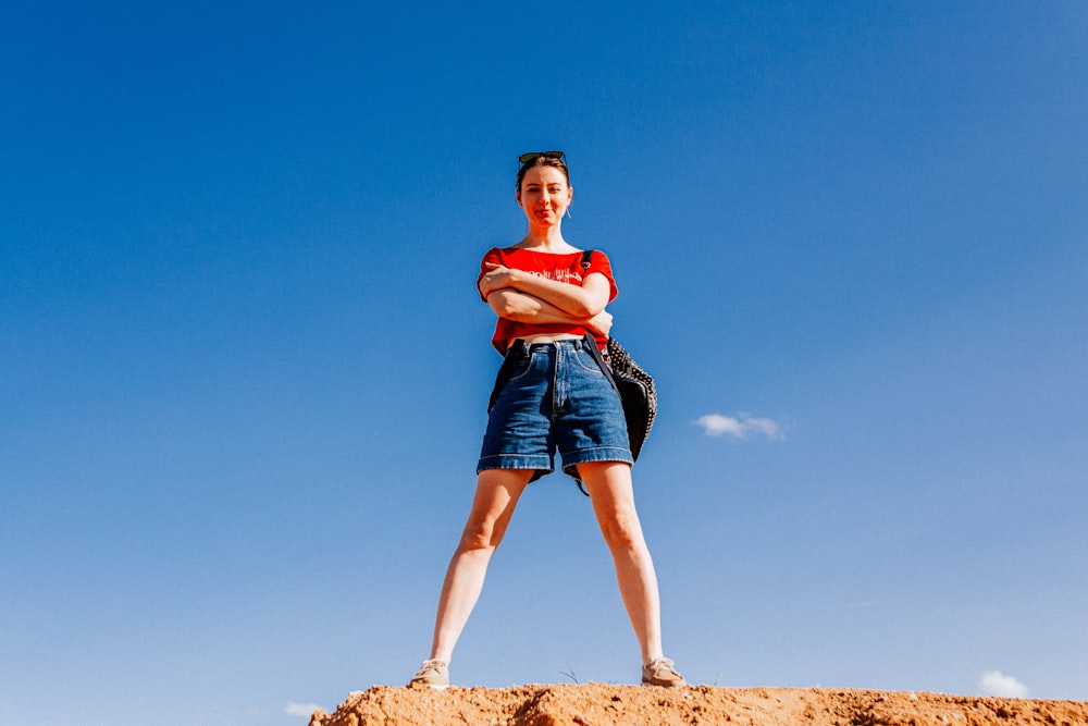 a woman standing on top of a dirt hill