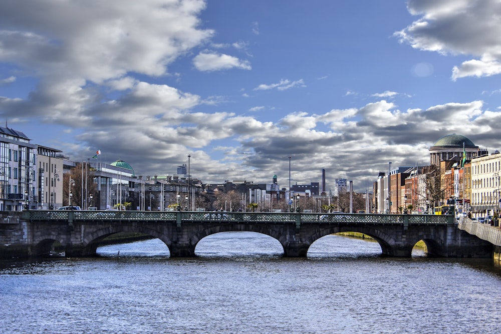 a bridge over a body of water with buildings in the background