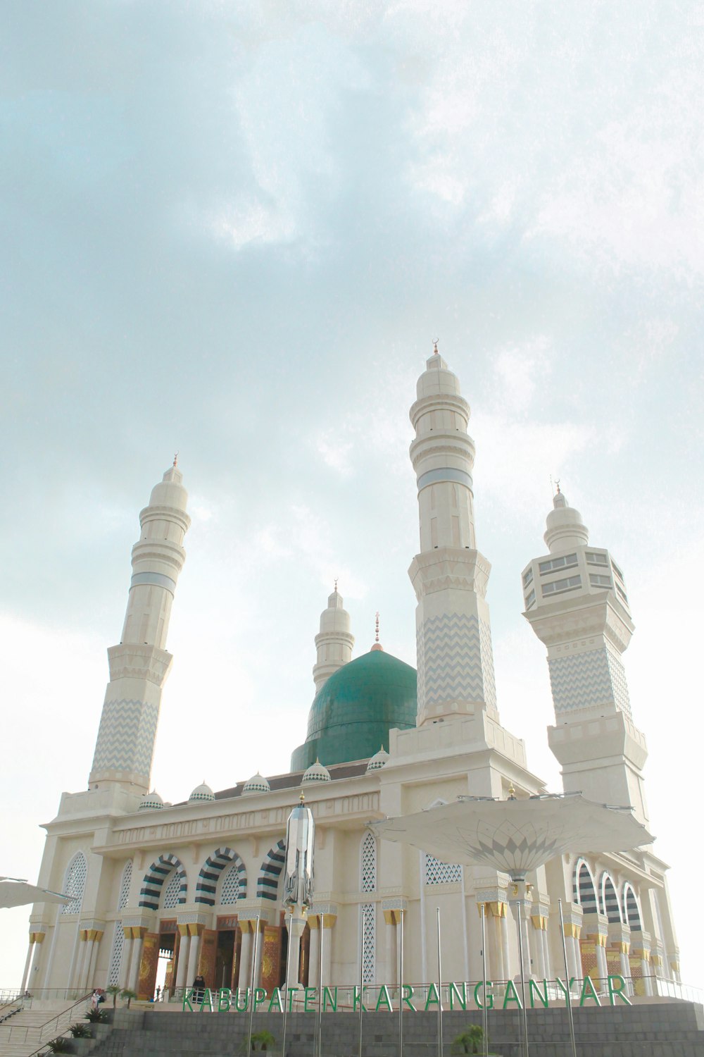 a large white building with a green dome