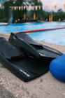 a pair of black flippers sitting next to a swimming pool