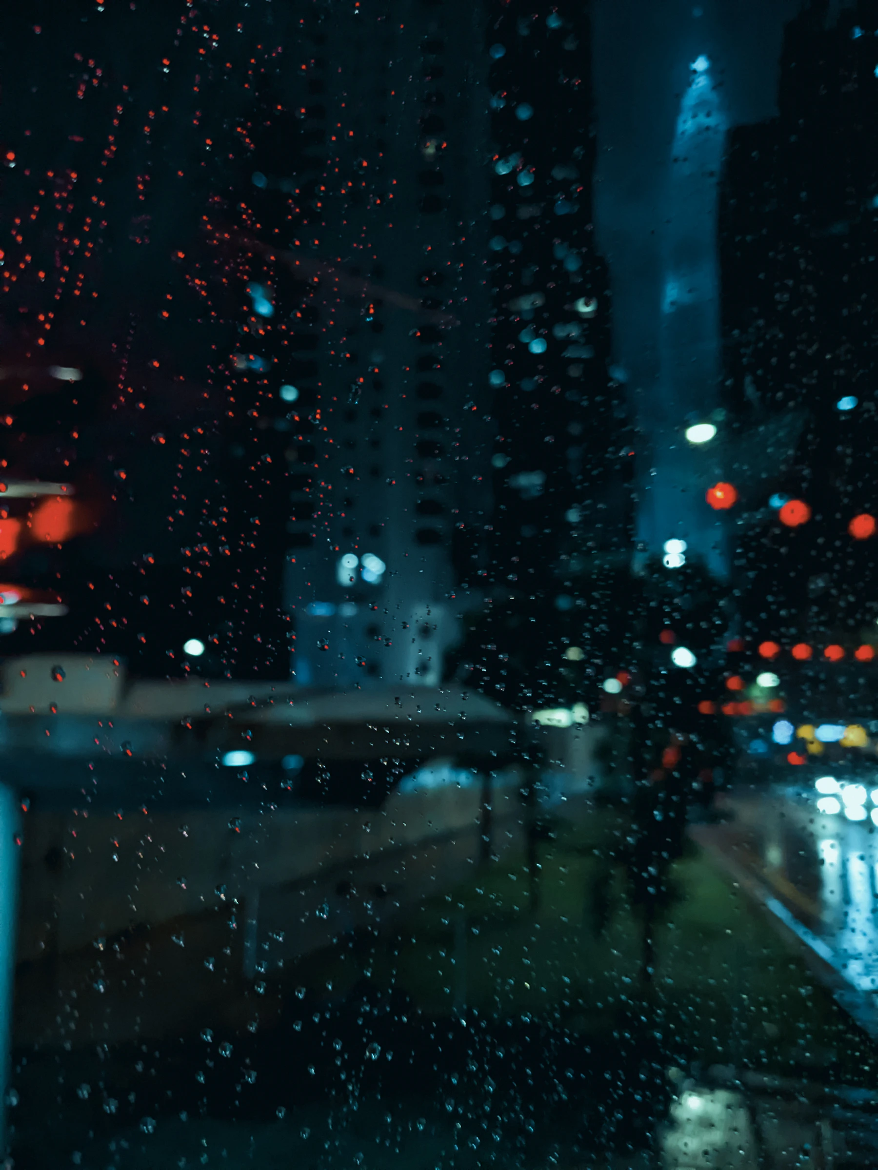 City lights seen through a rain-covered window at night
