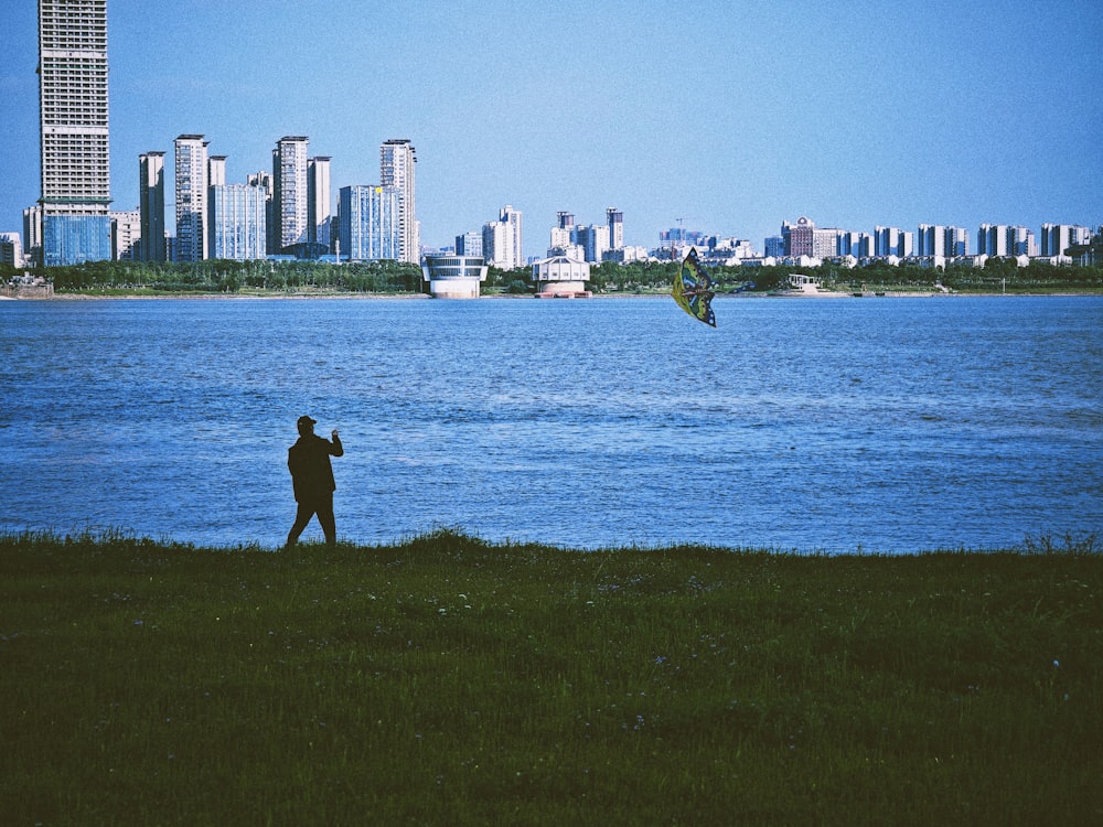 a man flying a kite near a body of water