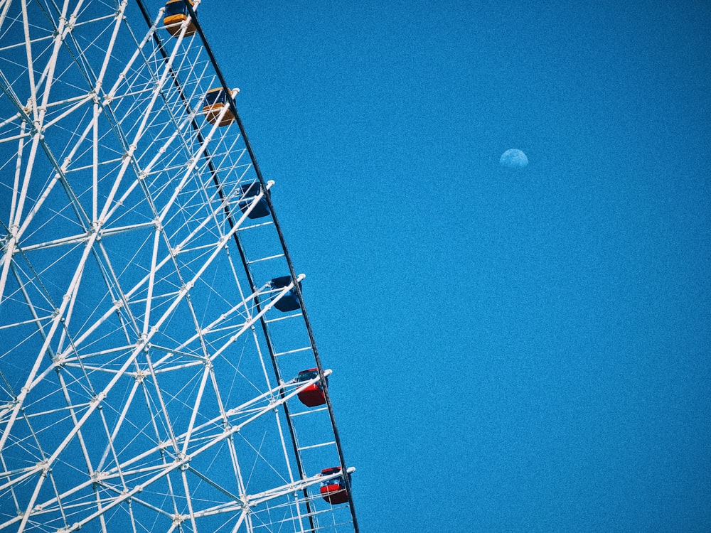a ferris wheel with a half moon in the background