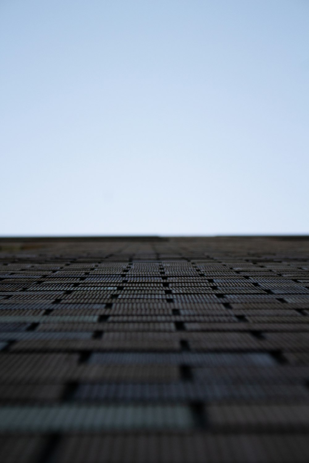 a close up of a brick wall with a sky background