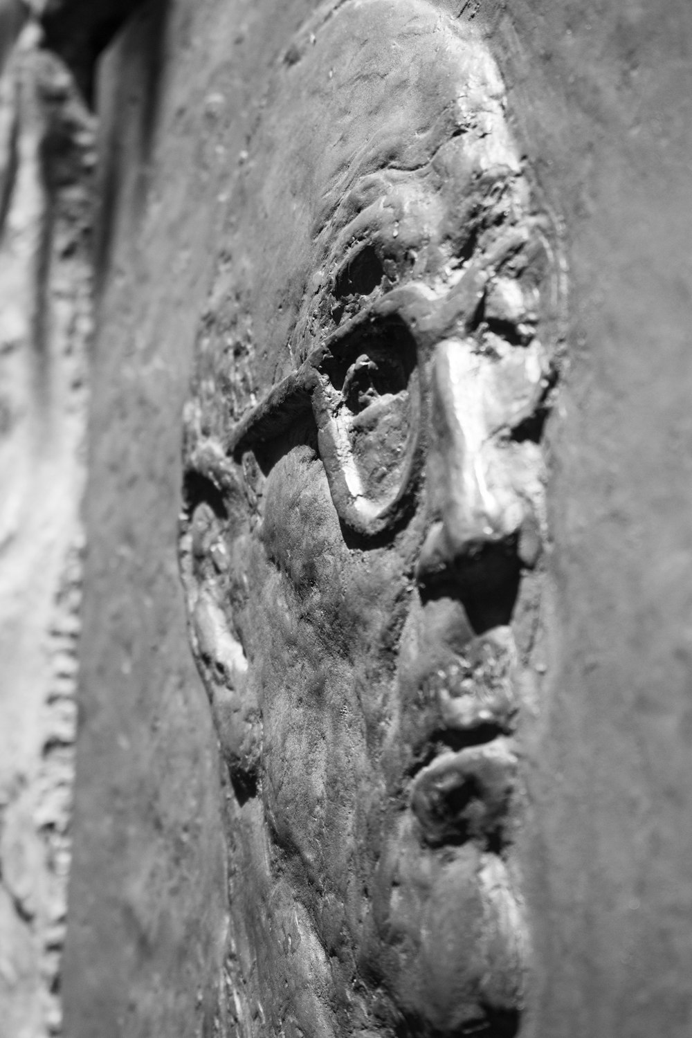 a black and white photo of a face on a wall