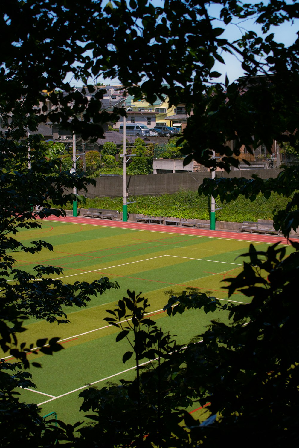 a view of a tennis court through some trees
