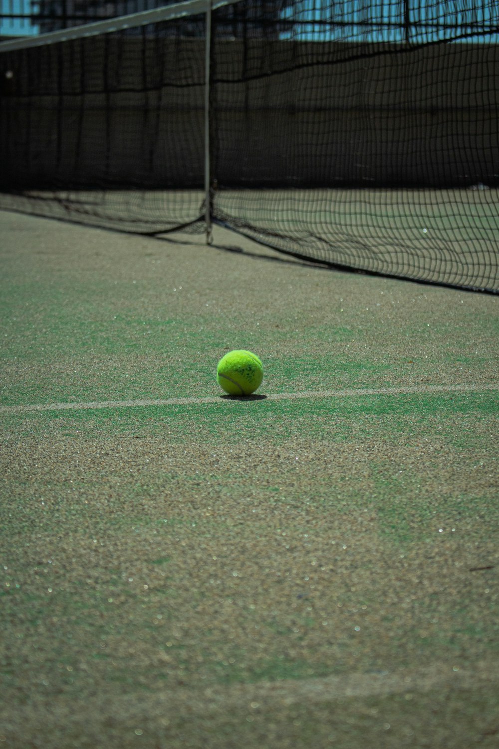 a tennis ball sitting on a tennis court