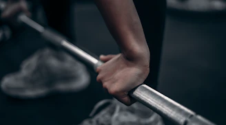 Close-up of hands gripping a barbell mid-deadlift in a home gym.