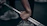 Close-up of rugged gym gloves gripping a heavy barbell under dramatic lighting.