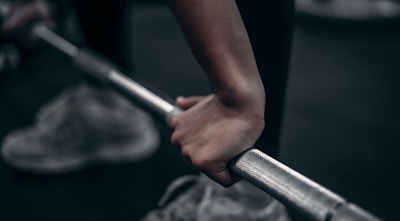 Close-up of hands adjusting weights on a barbell, showing focus on technique.