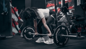 a woman lifting a barbell in a gym