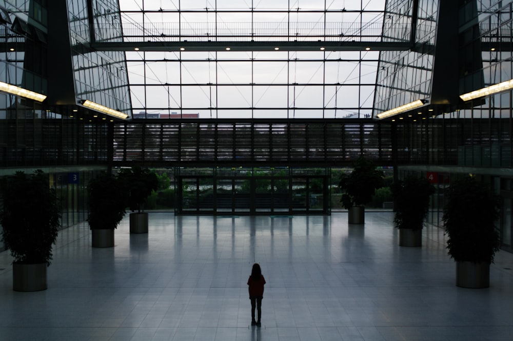 une personne debout seule dans un grand bâtiment