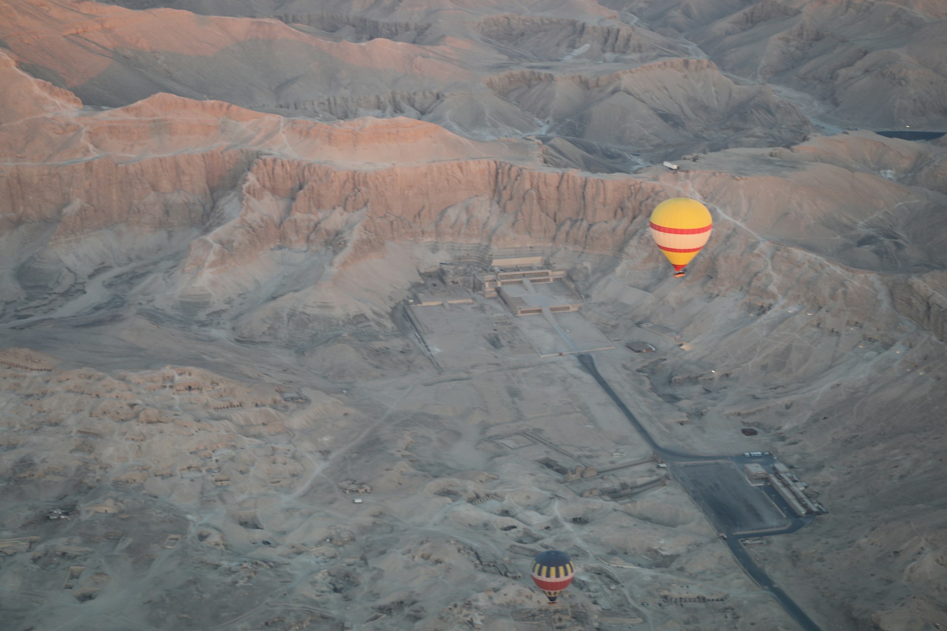 a hot air balloon flying over a mountain range