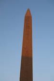 Intricate carvings on an ancient Egyptian obelisk standing tall amidst desert sands.