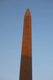 A close-up of an ancient Egyptian megalith engraved with mysterious symbols glowing softly in the desert sunset.