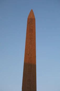 A close-up of an ancient Egyptian megalith engraved with mysterious symbols glowing softly in the desert sunset.