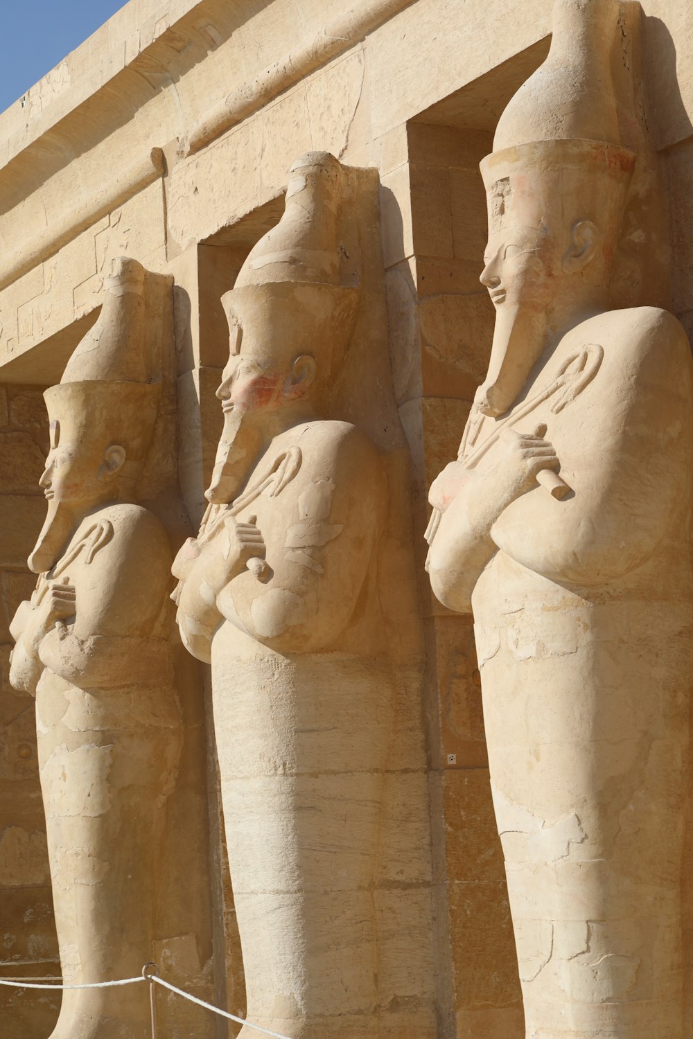 a row of statues of pharaohs in front of a building