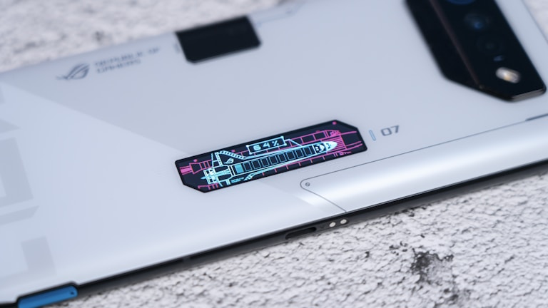A sleek, modern smartphone with futuristic design elements and a digital display panel showing graphics and numbers, placed on a textured surface.