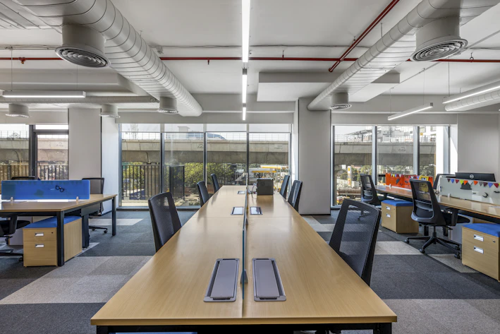 A sleek modern office setup with ergonomic chairs and minimalist desks bathed in natural light
