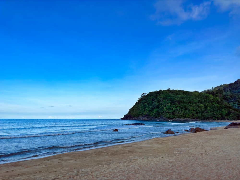 a sandy beach with a small island in the distance