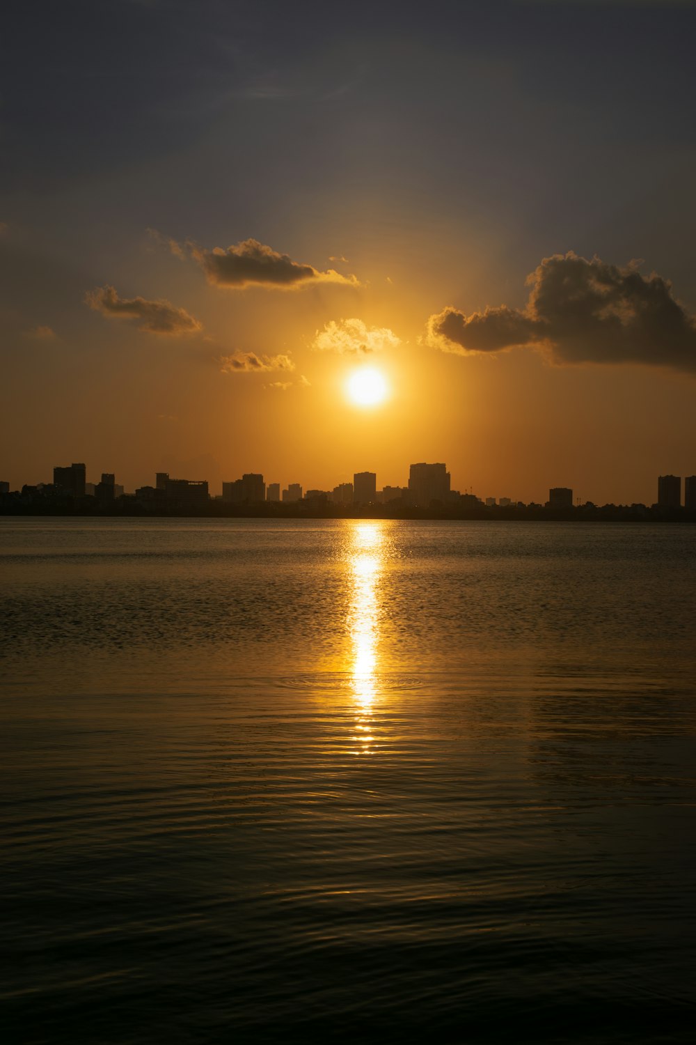 a large body of water with a sunset in the background