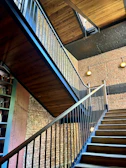 Floating staircase with hidden metal structure and thick wooden steps in an industrial setting.