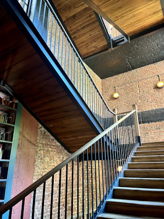 Floating staircase with hidden metal structure and thick wooden steps in an industrial setting.