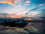A vibrant aerial view of Sunset Isle Yacht Club at sunset with boats docked and calm waters.