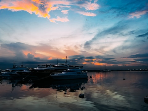 A vibrant aerial view of Sunset Isle Yacht Club at sunset with boats docked and calm waters.