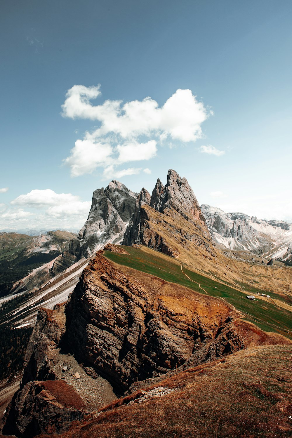 a view of a mountain range from the top of a hill